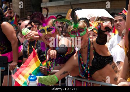 Chicago, Illinois, USA, 24. Juni 2012. Zwei maskierte junge Frauen sehen die 2012-Pride-Parade. Die Parade zog eine Menge von 850.000 Menschen. Stockfoto