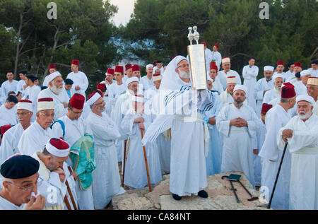 NABLUS, Westbank - 24 Juni: Ein Priester der alten Samaritan Gemeinschaft hält eine Tora-Rolle während der Feiertag von Schawuot Stockfoto