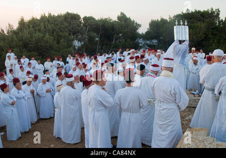 NABLUS, WEST BANK - 24 Juni: Ein Priester von der alten Samaritan Gemeinschaft hält eine Tora-Rolle während der Feiertag von Schawuot in Garizim am 24. Juni 2012 ist Schawuot einen Urlaub Commemoretas zum Jahrestag der Tag Gott den Israeliten die Thora gegeben haben Stockfoto