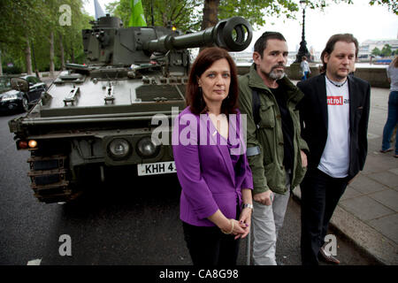 London, UK. Mittwoch, 27. Juni 2012. Spokespeople Anna Macdonald und Oliver Sprague mit verletzten Kriegsfotograf Paul Conway. Aktivisten und Unterstützer von Oxfam und Amnesty International, als Teil der Koalition Querlenker fahren einen Abt Pistole Tank um zentrale London die Notwendigkeit Stockfoto