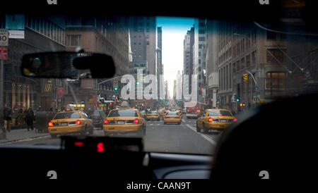 20. November 2003; New York, NY, USA; New York City berühmt Taxis. Motoring gelben Taxis fahren die Stadt Straßen Loking für Kunden. New Yorker Taxifahrer sind aus allen Ländern und aller Nationalitäten. Durch die Frontscheibe mit vielen Taxis auf der Straße gesehen. Stockfoto