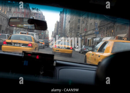 20. November 2003; New York, NY, USA; New York City berühmt Taxis. Motoring gelben Taxis fahren die Stadt Straßen Loking für Kunden. New Yorker Taxifahrer sind aus allen Ländern und aller Nationalitäten. Durch die Frontscheibe mit vielen Taxis auf der Straße gesehen. Stockfoto