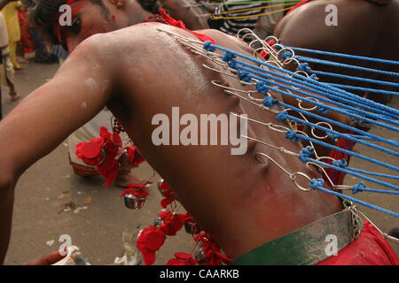 KUALA LUMPUR, MALAYSIA 5. Februar 2004 Devotee erstreckt sich seine Haut wie zieht er seine Begleiter angeschlossen, um der Rücken während der Prozession um den Tempel in Batu Höhlen am Stadtrand von Kuala Lumpur für Thaipusam Festival, Februar 5. 2004. 30 oder mehr Tage des Fastens und Stunden nach Durchführung der Cavadis erfordern Stockfoto