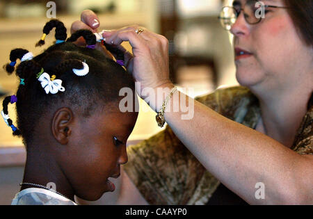 7. März 2004; San Antonio, TX, USA; KATHY JOHNSON stellt Spangen in ihrer neu angenommene Tochter CARINETTE Haare vor Versammlungen in der Oak Hills Kirche. Sie verbrachte den größten Teil ihres Lebens in einem Waisenhaus in Cap-Haiten, Haiti, bis ihr Adoptivvater Dan Johnson sie in die Vereinigten Staaten nur brachte eine Stockfoto