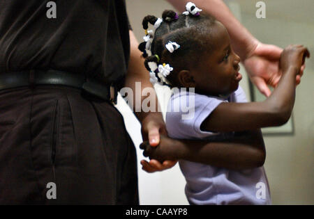 7. März 2004; San Antonio, TX, USA; CARINETTE JOHNSON, 7, wird bis in ihr Bruder des Holzes Arme nach dem Mittagessen verstrickt. Sie verbrachte den größten Teil ihres Lebens in einem Waisenhaus in Cap-Haiten, Haiti bis ihr Adoptivvater Dan Johnson sie in die Vereinigten Staaten nur wenige Tage brachte bevor Rebellen Kontrolle über erlangte die Stockfoto