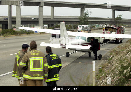 Alameda Feuerwehr Personal zusehen, wie FAA Ermittler sieht Denny Pollard in einer Cessna 172 die auf West-gebundenen Highway 580 in der Nähe der Autobahn 238 aufgeteilt in Castro Valley, Kalifornien, auf Montag, 24. Mai 2004 gelandet.  Pilot John (Nachname TK aus KWK) und sein Beifahrer, KCBS Verkehr Reporter Carl Tho Stockfoto