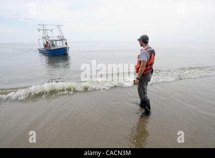 19. Juni 2010 - Venice, LOUISIANA, USA - US Fisch & Wildlife Service Biologe Chris Kriegner wartet ein Boot, um ihn von einer Insel entlang den Südpass des Mississippi River Delta in der Nähe von Venice, Louisiana, USA, 19. Juni 2010, während eine tägliche Suche für geölte Wildtiere abholen. Biologen mit den USA Stockfoto