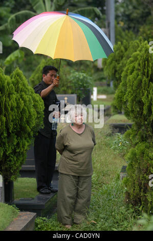 Australische Shirley Shackleton, Ehefrau des verstorbenen australischen Journalist Greg Shackleton, sitzt neben dem Grab in Jakarta.Indonesia. 9. Juli 2010, wo fünf Journalisten, die sogenannte Balibo Five, die in Ost-Timor 1975 getötet wurden, begraben wurden. Die Frau von einem australischen Reporter von angeblich getötet Stockfoto