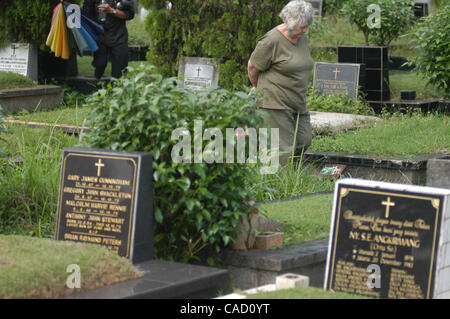 Australische Shirley Shackleton, Ehefrau des verstorbenen australischen Journalist Greg Shackleton, sitzt neben dem Grab in Jakarta.Indonesia. 9. Juli 2010, wo fünf Journalisten, die sogenannte Balibo Five, die in Ost-Timor 1975 getötet wurden, begraben wurden. Die Frau von einem australischen Reporter von angeblich getötet Stockfoto