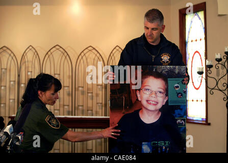 7. Juni 2010 organisieren - Portland, Oregon, US - Sheriff Offiziere ein Foto der noch fehlenden 7-Year-Old Kyron Horman an der Brooks Hill historische Kirche bereitet für eine weitere Pressekonferenz gegenüber Skyline Elementary School. Einerseits sind Multnomah County Sheriff Captain Jason Gates, FBI Special A Stockfoto