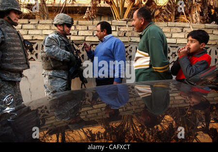 21. Februar 2008 spricht - Bagdad, Irak - Lt. LARRY PITTS, Bravo Batterie, 2. Bataillon der 319th Airborne Field Artillery Regiment, mit ein paar Einheimischen während einer Patrouille auf dem Fischmarkt in der sunnitischen Enklave des Shabakar im Stadtteil Rabi von Bagdad.  Wenn Pitts und andere Soldaten aus der Stockfoto