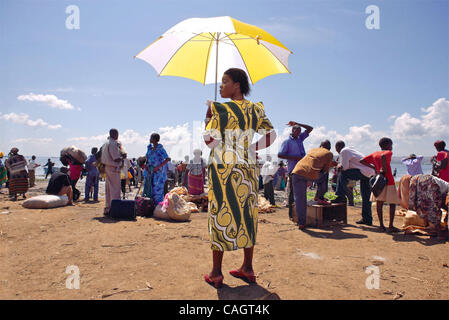 Eine Frau, die Abschirmung selbst von der Sonne, auf Masse-Anschluss. Stockfoto