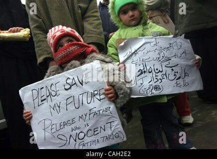 Ein paar Kinder Tariq Ahmed einer der Angeklagten von Bombenanschlägen in der Nähe von SimultaTearsneous in Neu-Delhi im Jahr 2005, Pla Karte während einer Protestaktion in Srinagar, der Sommerhauptstadt des indischen Teil Kaschmirs, 28, Jan halten.  2008.Jan. 2008. Fast Dutzend Angehörige von Tariq protestierten gegen Delhi Polizei und angebliche t Stockfoto