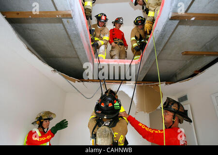 11. Dezember 2007 - West Palm Beach, Florida, USA - Feuerwehrleute üben "Nance Drill', einen Feuerwehrmann zu retten, die durch den Boden in einem niedrigeren Niveau gefallen ist.  Diese Bohrmaschine wurde entwickelt, nachdem ein Feuerwehrmann von Columbus, Ohio, John Nance, getötet worden war, nach einem Sturz über dem Mainfloor ein Haus-int Stockfoto