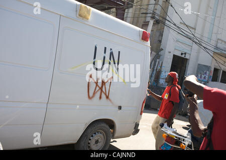 12. Januar 2011 sprühen malt ein Demonstrant - Port-au-Prince, Haiti - eine UN-Ambulanz, wie es geht die Demonstranten. Demonstranten mit der Gruppe nahm IRKEFD auf den Straßen von Haiti am einjährigen Jahrestag des Erdbebens. Die Gruppe sammelten sich gegen die Zwangsräumung der Menschen in Zeltlagern. (Cred Stockfoto