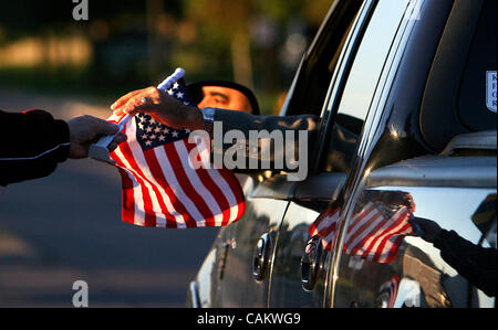 Brooklyn Park, MN - 11. September 2007 - Gary DeMars spiegelt sich in einem Auto, wie er Flaggen in der Nähe von einem Median auf Brooklyn Boulevard und Zane Avenue ausgehändigt.  DeMars und seinem Schwiegersohn Billy Bishop 1000 Fahnen online gekauft, um für den Verkehr in Brooklyn Park zu Truppen im Irak zu unterstützen und würdigen zu verteilen Stockfoto