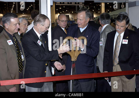 22. Januar 2004 - Reno, Nevada, USA - der ehemalige Präsident George Bush die übergroße Schere mit dem die zeremonielle rote Schleife geschnitten erhält anlässlich der Eröffnung des Konvents 2004 Safari Club International, einem jährlichen internationalen Markt von großen und kleinen Jagd und Fischerei-bezogene g Stockfoto