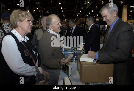 Teilen Sie 22. Januar 2004 - Reno, Nevada, USA - Harold und Gwen Becker, Minneapolis, Minnesota, sich einen lachen mit Oberst Oliver North wie er eines seiner Bücher für sie, bei der 2004 Safari Club International Convention, ein Marktplatz für Jagd und Fischerei-bezogenen waren und Dienstleistungen personalisiert, einschließlich saf Stockfoto