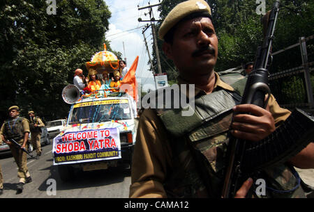 Indische paramilitärische Soldaten halten Vigil, wie sie Fuß entlang einer Shoba Yatra anlässlich "Janmashtami" die Geburt der Hindu Gott Lord Krishna in Srinagar, der Sommerhauptstadt des indischen Kaschmir, Indien, am Vorabend des Krishna Janamashtmi (Geburtstag von Lord Krishna) markiert. Lord Krishna, der achte o Stockfoto