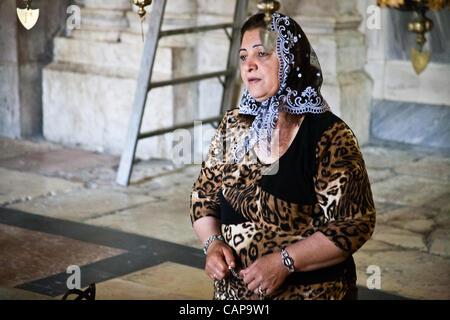 Eine Frau kniet vor der Stein Salbung in der Kirche des Heiligen Grabes am Gründonnerstag. Jerusalem, Israel. 5. April 2012. Stockfoto