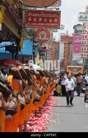 Bangkok, Thailand. 5. April 2012. Thailändischer buddhistischer Mönche gehen auf Rosenblätter verstreut von Anhängern. Mehr als tausend Mönche im Wat Phra Dhammakaya nehmen Teil an einer Wallfahrt zu Fuß durch inneren Bereichen von Bangkok, was zu Kritik, dass es unangemessen und verursacht Probleme für den Verkehr ist. Stockfoto