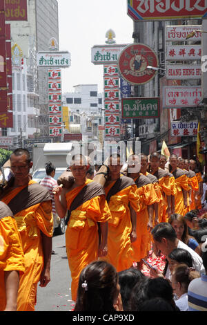 Bangkok, Thailand. 5. April 2012. Thailändischer buddhistischer Mönche gehen auf Rosenblätter verstreut von Anhängern. Mehr als tausend Mönche im Wat Phra Dhammakaya nehmen Teil an einer Wallfahrt zu Fuß durch inneren Bereichen von Bangkok, was zu Kritik, dass es unangemessen und verursacht Probleme für den Verkehr ist. Stockfoto