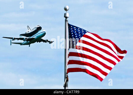 Das Space Shuttle befestigt Entdeckung seiner 747 Verkehr geht über eine US-Flagge während einer Überführung von der Hauptstadt der Nation 17. April 2012 in Washington, DC. Das Shuttle wird eine Ausstellung im Smithsonian Air and Space Museum. Entdeckung, zusammen mit dem Rest der Shuttle-Flotte wurde eingestellt. Stockfoto