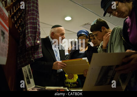 Yosef Kleinman, 82, Holocaust-Überlebender, ist umgeben von aufgeregt Mitglieder der bereschit (Genesis) Synagoge nach seiner Ansprache am Vorabend des Holocaust Märtyrer und Helden Remembrance Day. Bet-Shemesh, Israel. 18. April 2012. Stockfoto