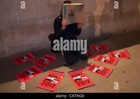 London, UK. 20.04.12. Kony 2012 Demonstrant legt seine Plakate auf dem Bürgersteig auf dem Trafalgar Square während ihrer Decke der Nacht-Kampagne. Rund 30 Demonstranten nahmen an der Veranstaltung, anstatt den 1000 erwartet. Stockfoto