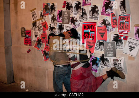 London, UK. 20.04.12. Kony 2012 Demonstranten mit Klebeband zusammen vor Poster an der Wand von der National Portrait Gallery am Trafalgar Square während ihrer Decke der Nacht-Kampagne. Rund 30 Demonstranten nahmen an der Veranstaltung, anstatt den 1000 erwartet. Stockfoto