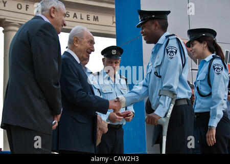 Präsident Shimon Peres schüttelt die Hand gegossene und erweiterte Personal-Sergeant-Major Hadar Marsha, stützte sich auf eine Krücke und erholt sich noch von einer Verletzung im Dienst für sein außergewöhnliches Verhalten und gratuliert. Jerusalem, Israel. 23. April 2012. Stockfoto