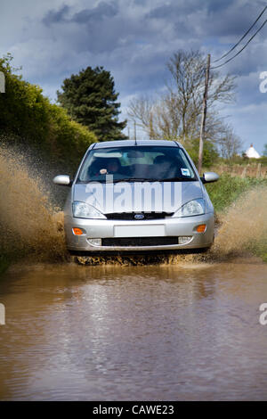 Starker Regen verursacht Überschwemmungen in North Norfolk, Großbritannien auf Donnerstag, 26. April 2012. Ein Auto durchläuft den Fluten auf einen Feldweg. Stockfoto