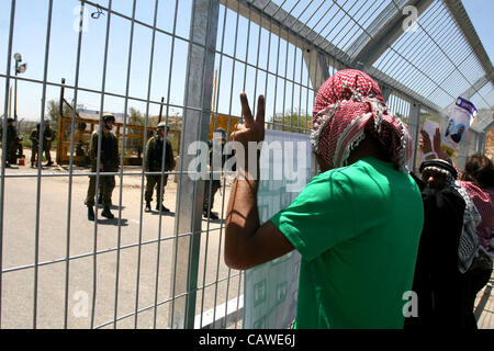 26. April 2012 - Ramallah, Westjordanland, Palästina - palästinensische Demonstranten halten Bilder von palästinensischen Gefangenen in Israel, wie er israelische Soldaten an der Bitwonia Gesichter Kreuzung außerhalb des israelischen militärischen Gefängnisses von Ofer, auf 64. Unabhängigkeitstag Israels, 26. April 2012. Palästinensische Stockfoto