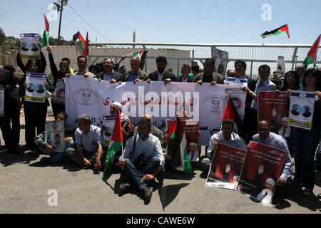 26. April 2012 - Ramallah, Westjordanland, Palästina - palästinensische Demonstranten halten Bilder von palästinensischen Gefangenen in Israel, wie er israelische Soldaten an der Bitwonia Gesichter Kreuzung außerhalb des israelischen militärischen Gefängnisses von Ofer, auf 64. Unabhängigkeitstag Israels, 26. April 2012. Palästinensische Stockfoto