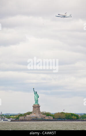 Space Shuttle-Prototyp "Enterprise"--auf die NASA 747 Shuttle Trägerflugzeug--fliegt über die Statue of Liberty auf dem Weg zum Flughafen JFK und letztlich auf dem Display an das Intrepid Sea Air and Space Museum. New York City, NY, USA, 27. April 2012. Stockfoto