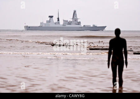 Sonntag 29. Ost Royal Navy Art 45 Zerstörer HMS Dragon verlässt Liverpool auf den Fluss Mersey. Der Zerstörer kam am Freitag für einen dreitägigen Besuch in Liverpool. Im Vordergrund ist einer von Antony Gormley Iron Men auf Crosby Strand. Stockfoto