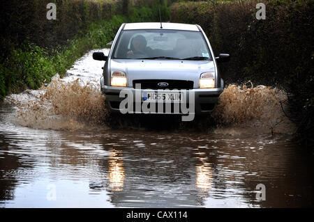 Eine Familie Limousine fährt durch Hochwasser auf einer Straße nahe Netherbury, Dorset, England am Montag, 30. April 2012. Das Met Office sagt, es ist die feuchteste April aktenkundig. Viele Teile des Vereinigten Königreichs sind Überschwemmungen auftreten. Stockfoto