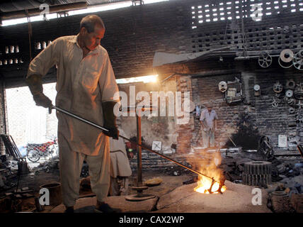 Eine Arbeit beschäftigt bei der Arbeit in einem Workshop auf der Eve Welt Labor Day in Lahore auf Montag, 30. April 2012. Stockfoto