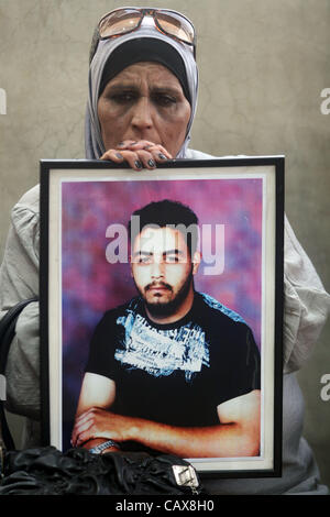 1. Mai 2012 - hält Ramallah, Westjordanland, Palästinensische Autonomiegebiete - Palästinenserin Porträt von einem Gefangenen in Israel während einer Kundgebung in Solidarität mit den Gefangenen in israelischen Gefängnissen außerhalb des Roten Kreuzes, die Gebäude in der Westbank-Stadt Ramallah am 1. Mai 2012. Foto von Issam Rimawi (Credit ich Stockfoto