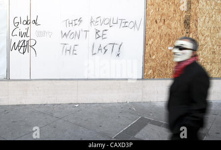 1. Mai 2012 Tausende durch die Innenstadt von Oakland, Kalifornien für eine Reihe von May Day März besetzen - Oakland, CA, USA - ein unbekannter Mann in eine Guy Fawkes Maske Spaziergänge durch eine verunstaltete Wand Proteste am 1. Mai 2012. (Bild Kredit: Josh Edelson/ZUMAPRESS.com ©) Stockfoto