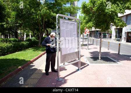 Wahlen in Griechenland, Athen, Griechenland. 05.05.2012 Bild zeigt eine ältere griechische Mann zu finden, seine Abstimmung Lokalsender auf eines der Auflistung Boards im Zentrum von Athen, vor morgen griechischen Parlamentswahlen angezeigt. Stockfoto