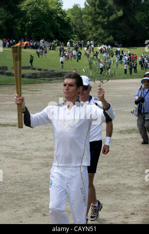 10. Mai 2012 - Olympia, Griechenland - SPYROS GIANNIOTIS, Griechenlands Weltmeister schwimmen, trägt das Feuer während der Fackel Beleuchtungszeremonie von London 2012 Olympische Spiele auf dem Gelände des antiken Olympia. (Bild Kredit: Aristidis Vafeiadakis/ZUMAPRESS.com ©) Stockfoto