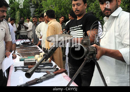 CID Polizeibeamte überprüfen beschlagnahmten Waffen und Kugeln, die während der Pressekonferenz CID Büro in Karatschi am Freitag, 11. Mai 2012 in einem Raid wiederhergestellt wurden. Stockfoto