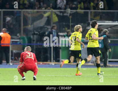 12.05.2012. Berlin Olympia Stadion, Deutschland. Münchens Bastian Schweinsteiger kniet auf dem Boden (L) während der Dortmunder Spieler während der deutsche DFB-Pokal Finale Fußballspiel feiern zwischen Borussia Dortmund und FC Bayern München im Olympiastadion in Berlin, Deutschland Stockfoto