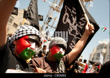 RAMALLAH, Palästinensische Autonomiegebiete - 15. Mai 2012: Gesichter gemalt mit der palästinensischen Flagge und einen Banner lesen 'Return', palästinensischen Jungen Marsch durch die Straßen von Ramallah am Nakba Day winken, wurde den modernen Bundesstaat zum Gedenken an die "Katastrophe", die palästinensischen Flüchtlinge aus was vertrieben Stockfoto