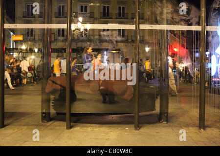 Madrid, Spanien. Ein Obdachloser schläft während Demonstranten vorbei ihn bei einem massiven Protest am 15. Mai 2012 in Madrid stattfand.  Dieser Tag war den erste Jahrestag des spanischen Indignado Bewegung, die ähnliche Occupy-Proteste rund um den Globus entfacht. Stockfoto