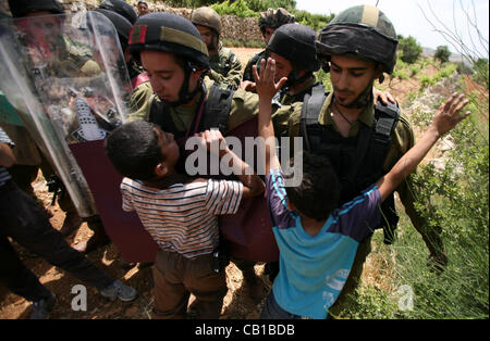 19. Mai 2012 - Hebron, Westjordanland - palästinensische Kinder konfrontieren israelische Soldaten während einer Demonstration nördlich von Hebron, wo israelische Soldaten Demonstranten gewaltsam nahe dem Eingang der jüdischen Besiedlung von Karmi Tsour entfernt. Einige Palästinenser wurden verhaftet. (Kredit-Bild: © Mamoun Wazwa Stockfoto