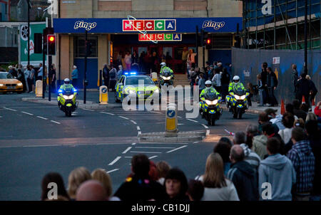 Eine Autokolonne von Polizei-Motorräder und Autos stehen die Olympische Fackel-Relais-Läufer durch die Straßen von Plymouth, Devon, England am 19. Mai 2012. Stockfoto