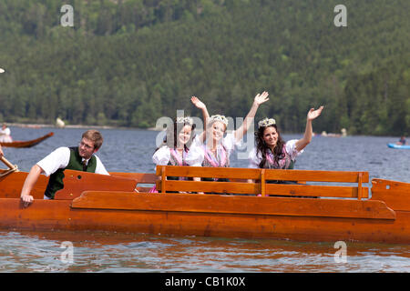 Die Narcissus Queen (Anna-Lena Stocker (Mitte)) und die Prinzessinnen (Andrea Maria Gautsch (rechts) und Karola Pliem (links)) auf dem Boot bei der Bootsparade der 53. Narcissus-Festival auf dem Altausseer See im Ausseerland, Salzkammergut, Steiermark, Österreich, am Sonntag, 20. Mai 2012. Stockfoto