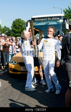 Olympische Fackel-Staffel bei Longwell Green, Bristol, UK, 2012 als zwei Träger über tauschen und die neue Fackel anzünden. Stockfoto